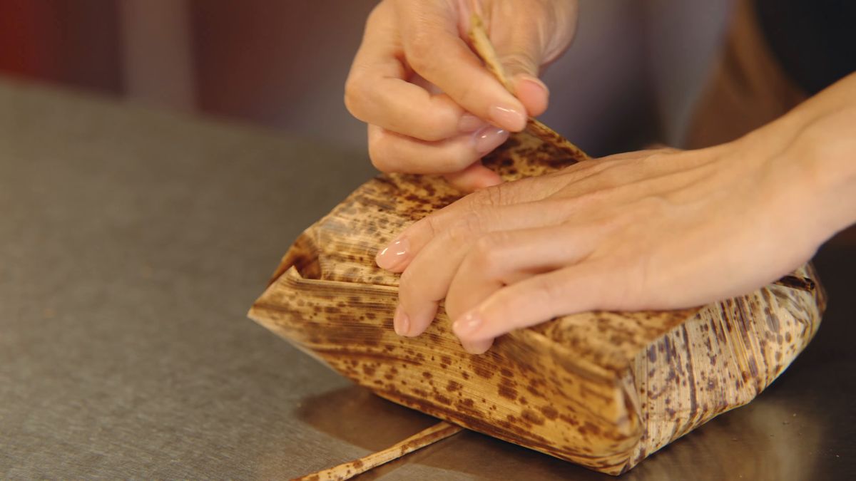 竹の皮でサンドイッチを包む手元