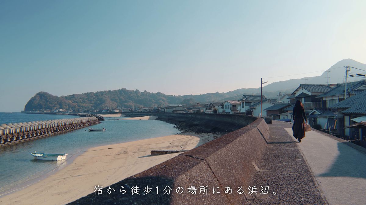防波堤の道を浜へ歩く後ろ姿