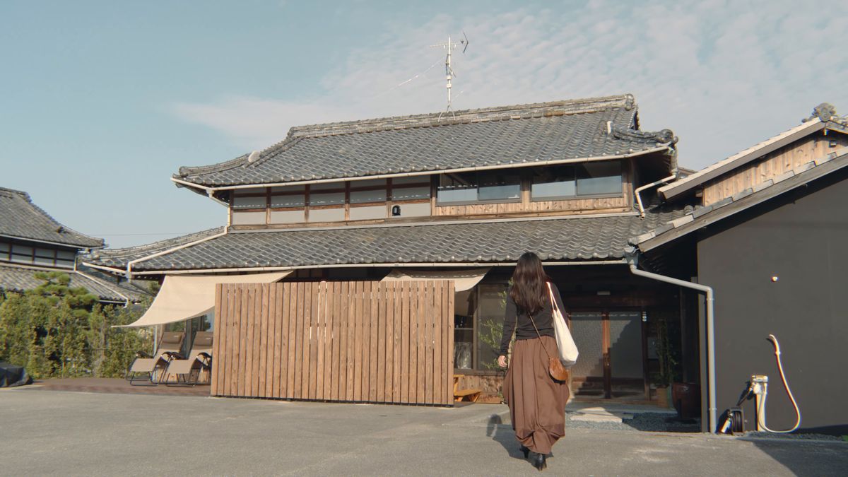 瓦屋根の古民家へ戻る後ろ姿