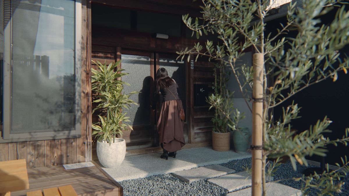 玄関の引き戸を開ける後ろ姿