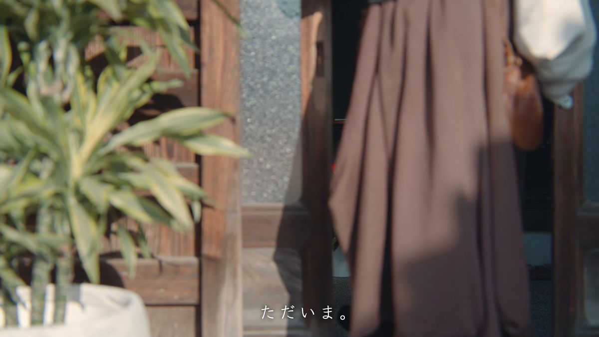 観葉植物のそばで玄関に入る後ろ姿の寄り