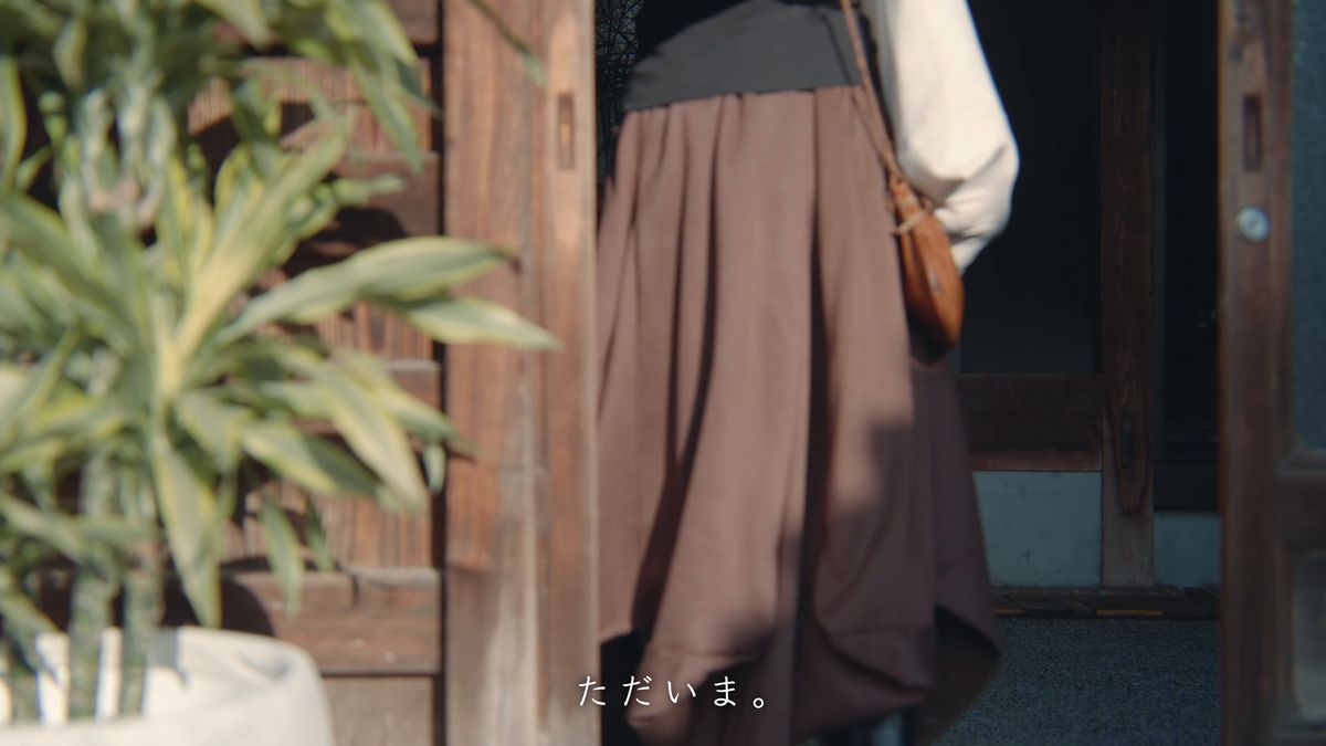 玄関の戸をくぐる後ろ姿