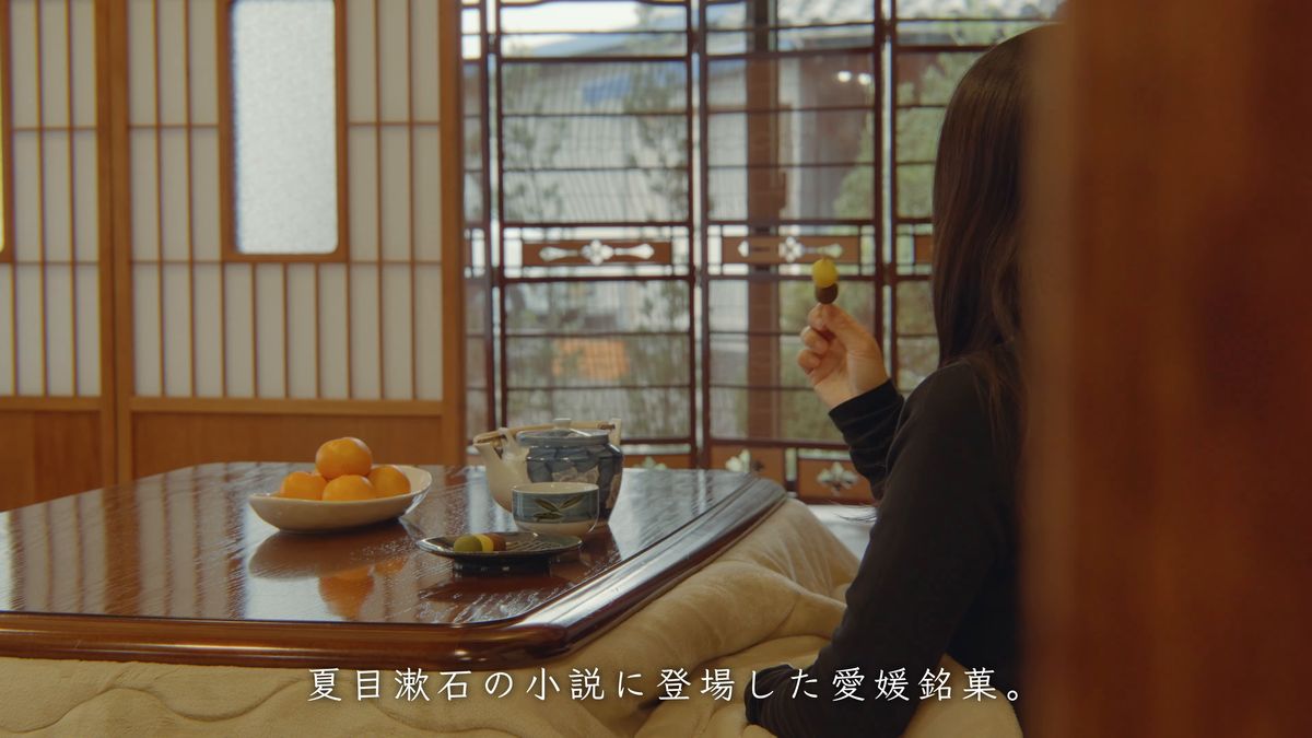 座敷のテーブルで団子を食べる後ろ姿