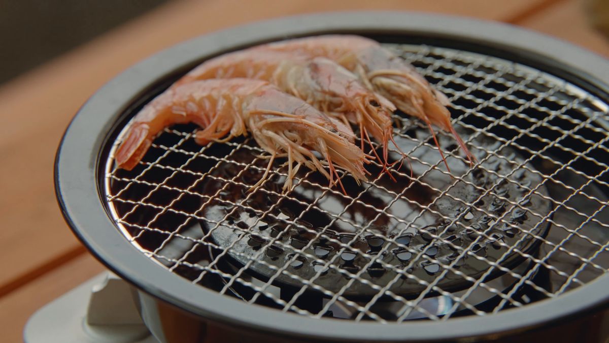 七輪の網で焼く有頭のエビ