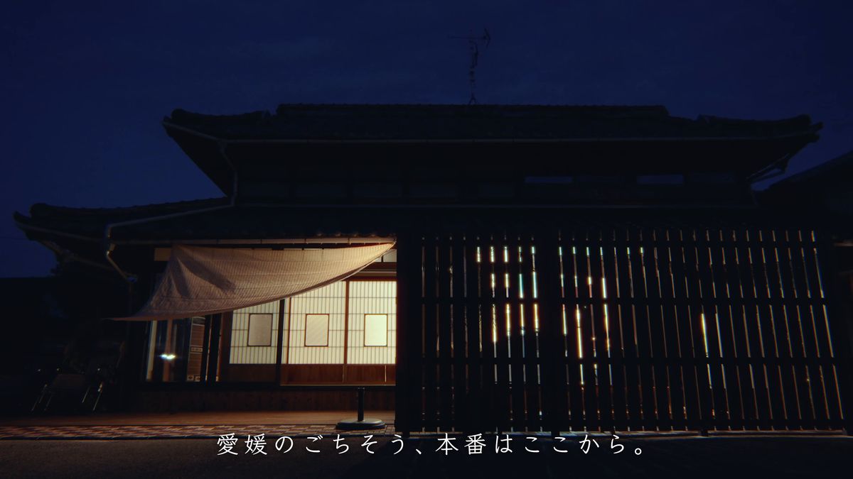 夜の古民家の外観と明かりのともる窓