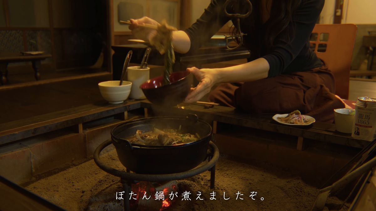 囲炉裏の前で鍋の具を取り分ける
