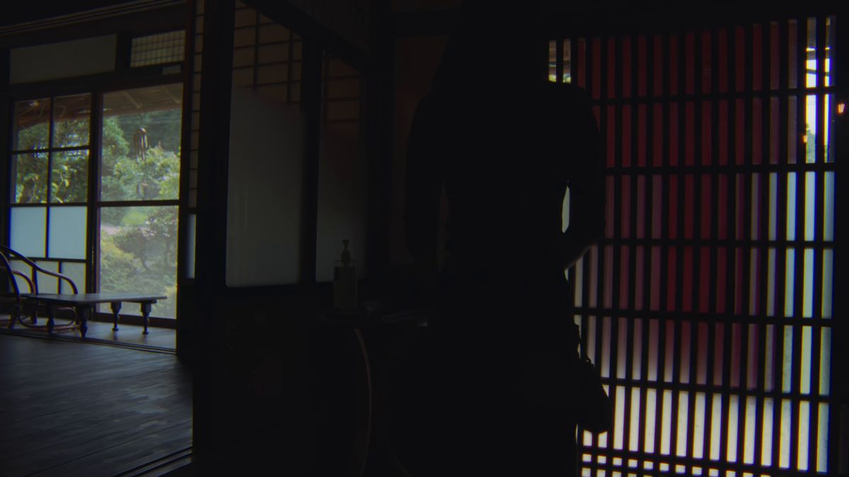 薄暗い格子戸の部屋に立つ人影