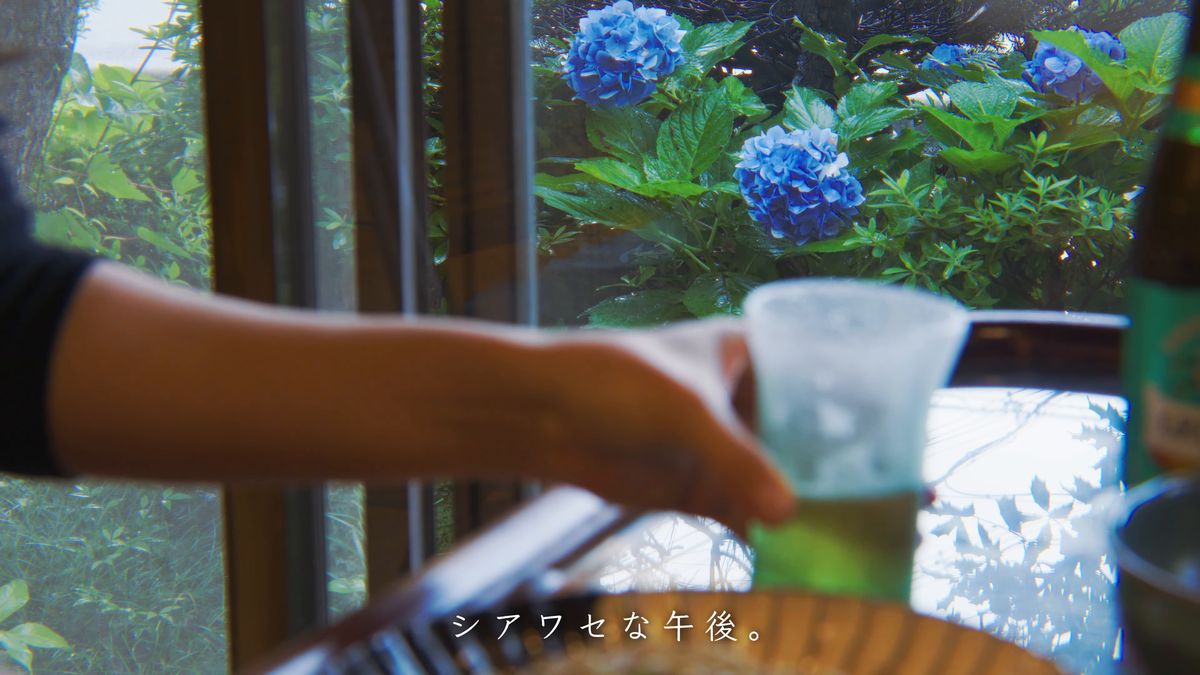 グラスを手に取る手元と、窓の紫陽花