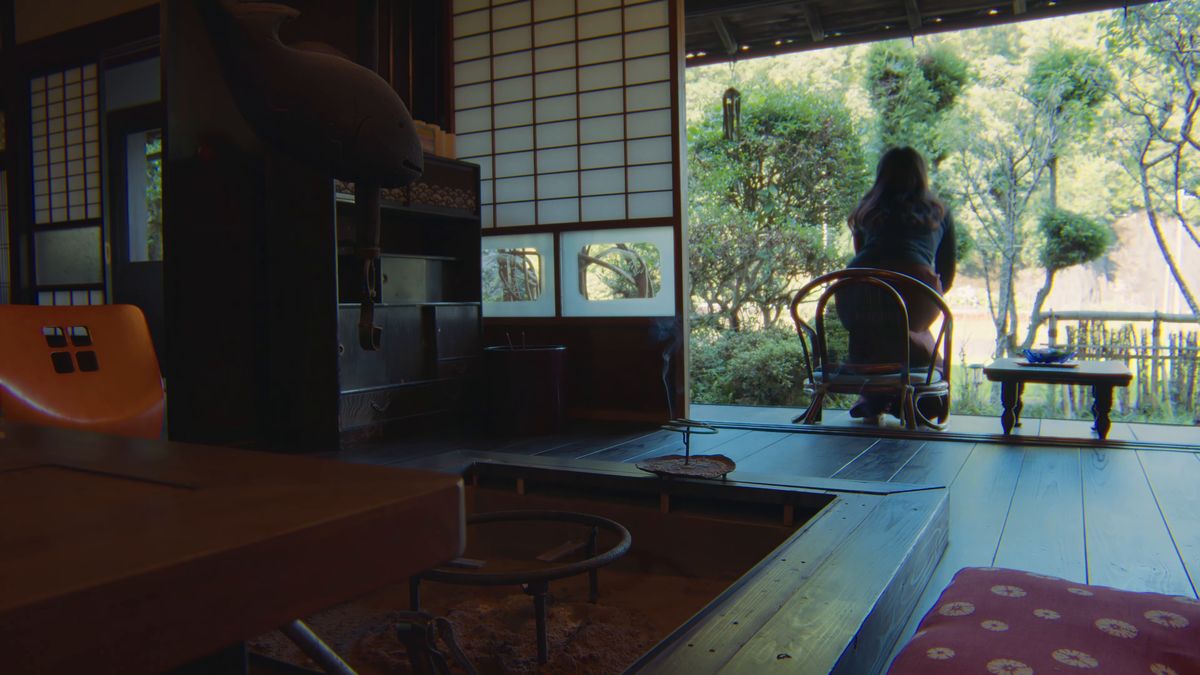 囲炉裏の間から庭を眺める後ろ姿