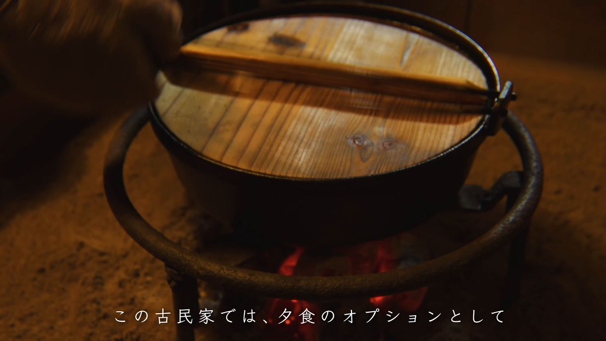 炭火の上に木の蓋をした鉄鍋
