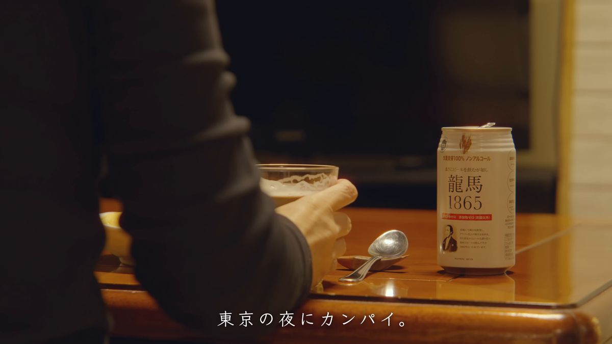 ノンアルコールビールの缶と、グラスを持つ手