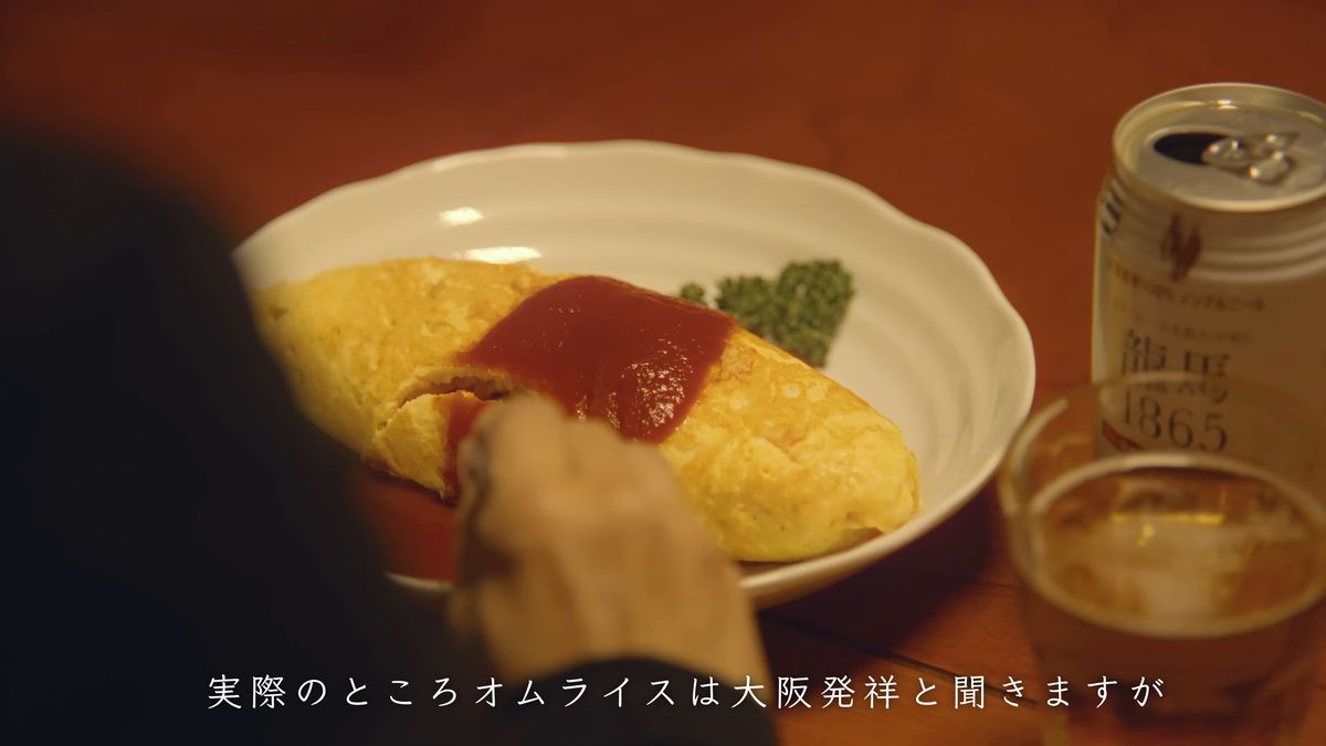 オムライスの皿と缶とグラスの並ぶ食卓