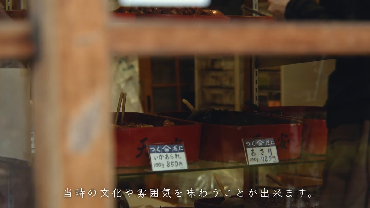 ガラスケースに並ぶ佃煮と、いかあられ・あさりの値札