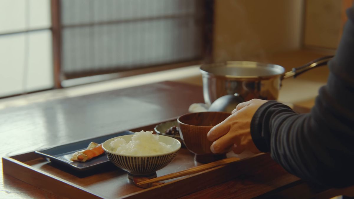 障子の前の座卓に膳を置く手元