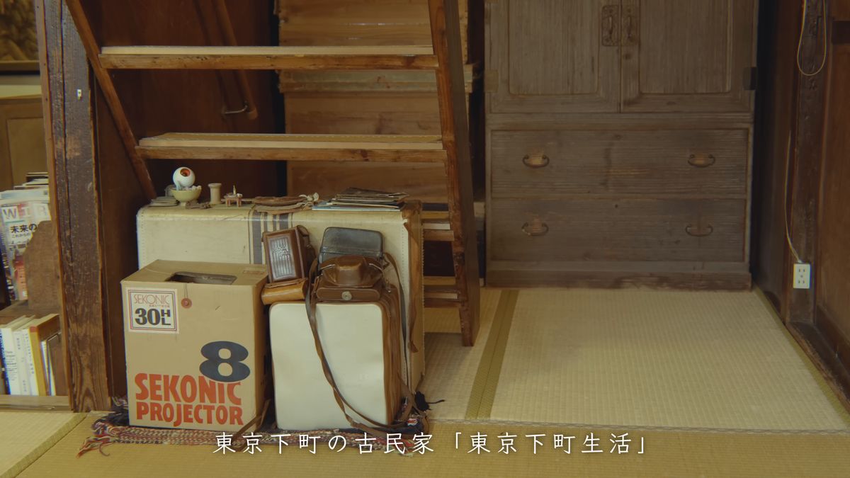 木の棚の下に置かれた古い映写機の箱