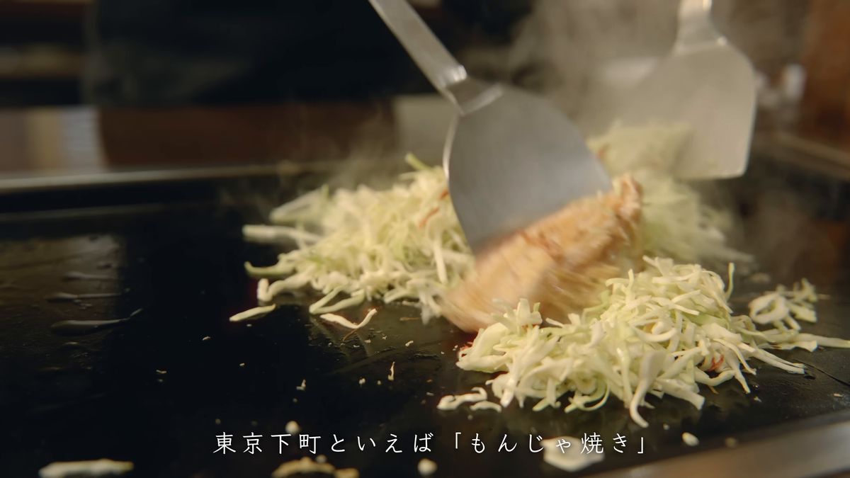 ヘラでキャベツと薄切り肉を刻みながら炒める
