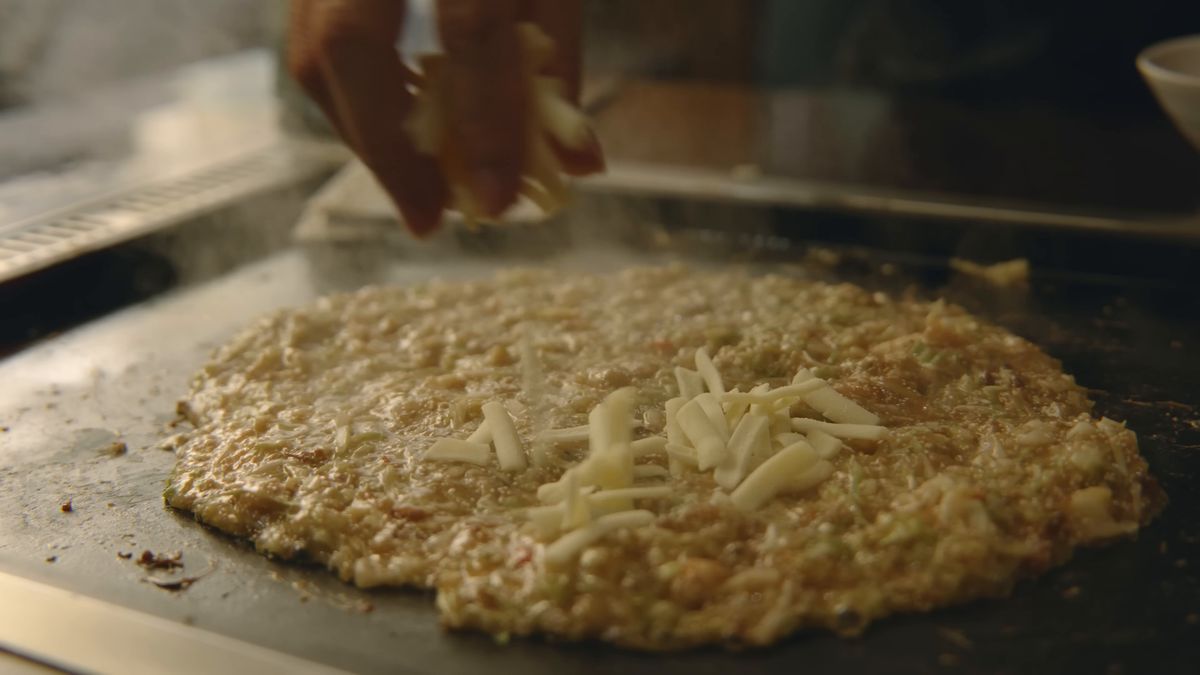 もんじゃにチーズをのせる手元