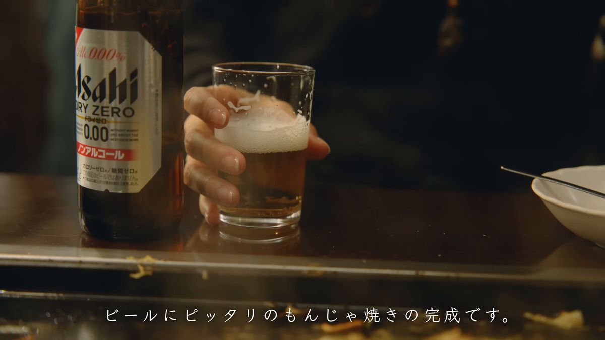 ノンアルコールビールの瓶と、注いだグラスを持つ手