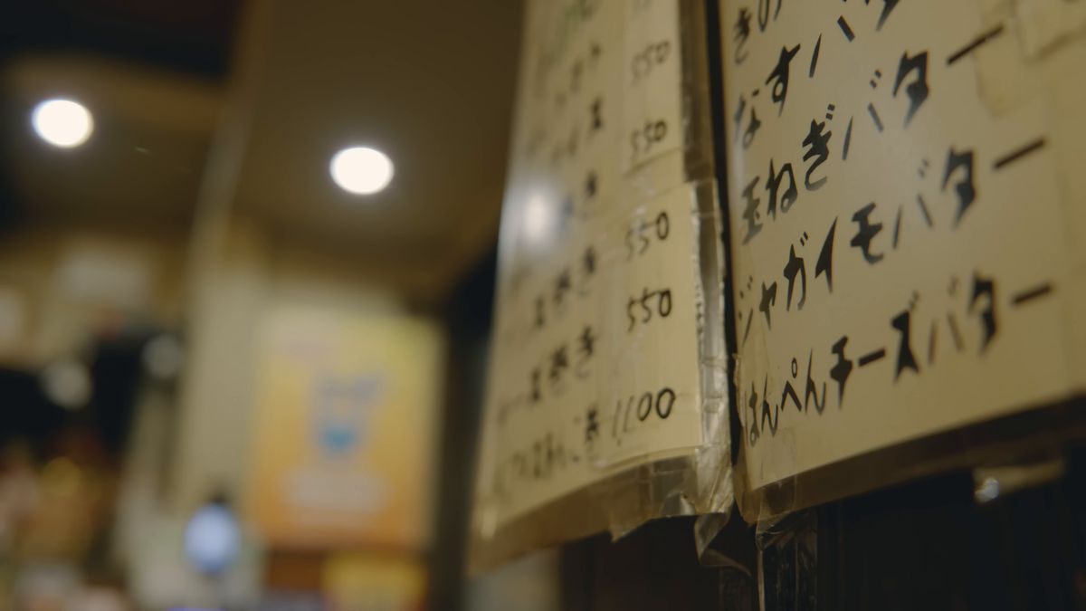 壁に並ぶ「なすバター」「玉ねぎバター」の手書きの品書き