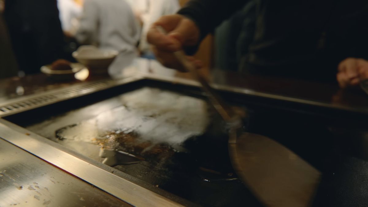 鉄板に生地を薄く広げる手元