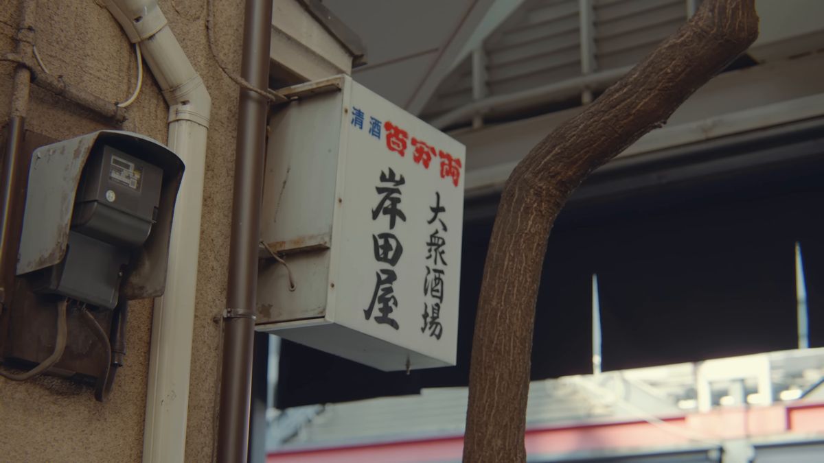 電柱の脇に掛かる「大衆酒場 岸田屋」の看板