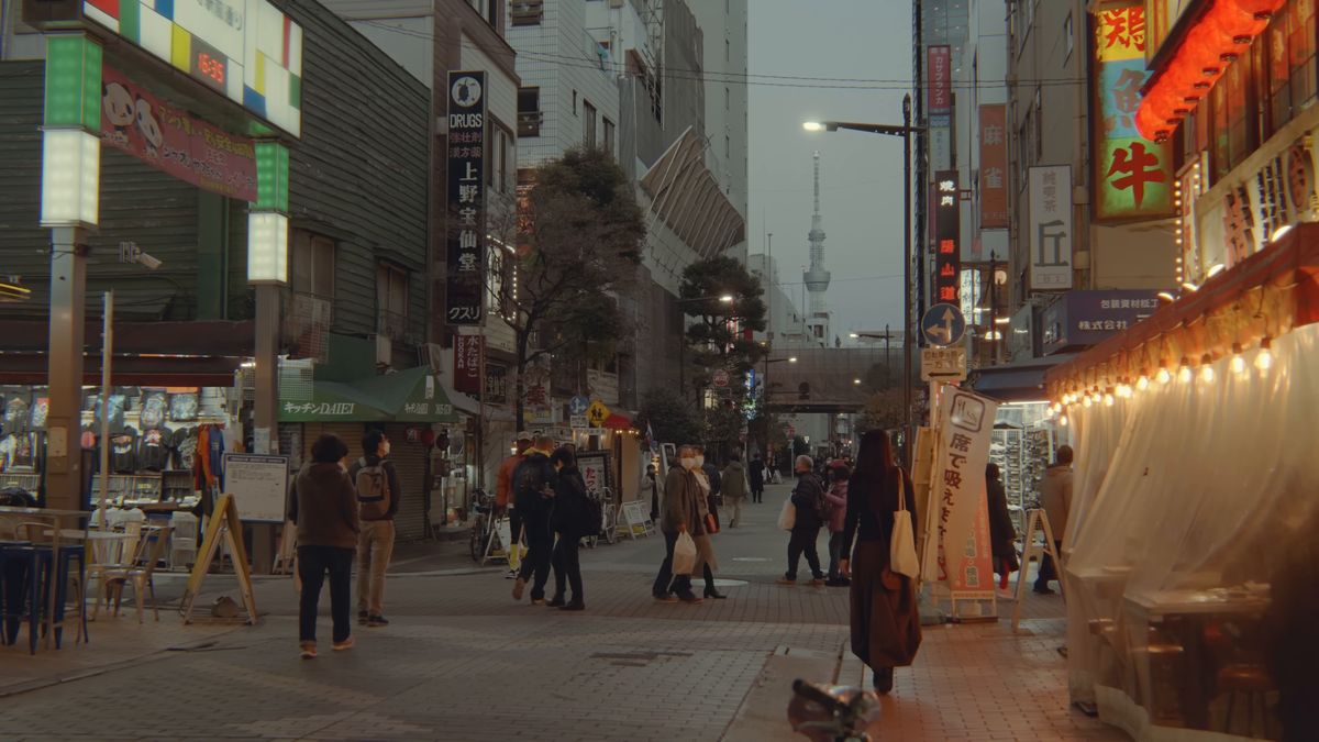 看板の灯り始めた夕暮れの上野の通り